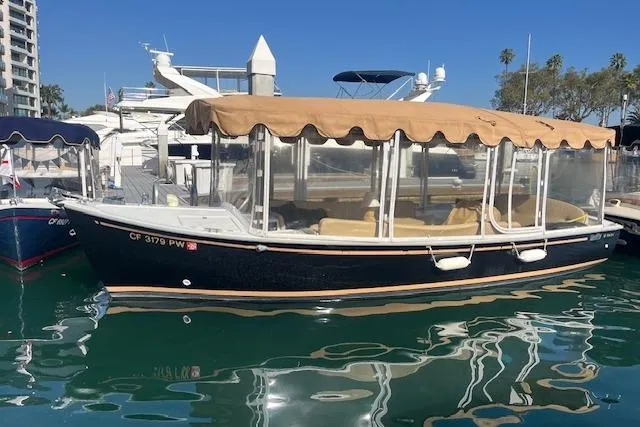 The Image of 2002 Duffy Classic 21 boat docked in marina with tan canopy and clear side panels. - 0
