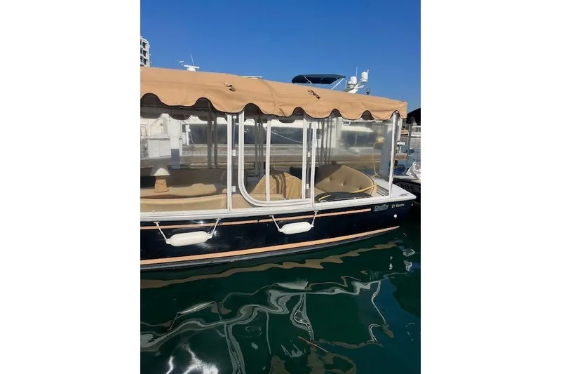 Slide: The Image of 2002 Duffy Classic 21 boat with tan canopy docked on calm water. - 1