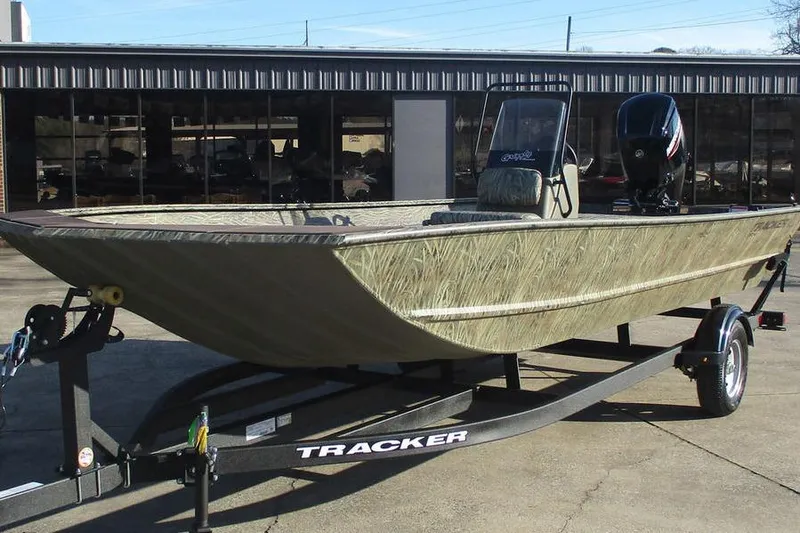 Slide: The Image of 2026 Tracker Grizzly 2072 CC boat on trailer, camo design, parked outdoors. - 8