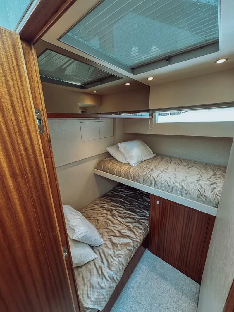Slide: The Image of Bunk beds in 2015 Ocean Alexander 72 yacht cabin, featuring wood paneling and cozy bedding. - 15