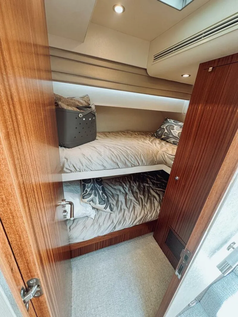 Slide: The Image of Bunk beds in 2015 Ocean Alexander 72 yacht cabin with wood paneling and cozy bedding. - 22
