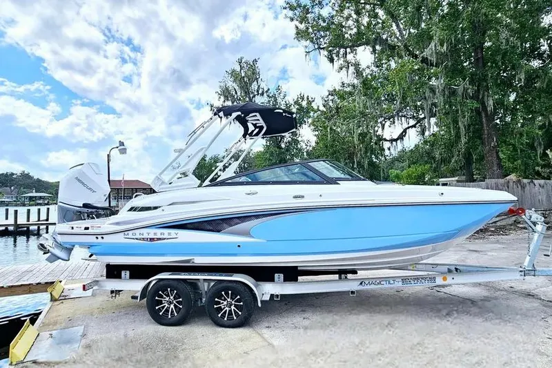 Slide: The Image of 2026 Monterey M-45 boat on trailer by waterfront, under cloudy sky. - 2