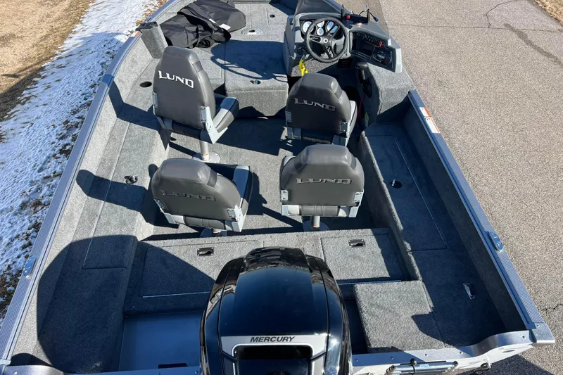 Slide: The Image of 2016 Lund 1675 Impact Sport fishing boat on snowy ground, featuring spacious seating and deck. - 13