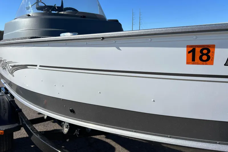 Slide: The Image of 2016 Lund 1675 Impact Sport boat side view with logo and trailer. - 17