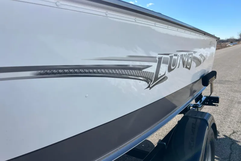 Slide: The Image of 2016 Lund 1675 Impact Sport boat on trailer, side view, outdoors. - 23