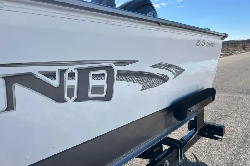 Slide: The Image of 2016 Lund 1675 Impact Sport boat side view with logo and trailer. - 24