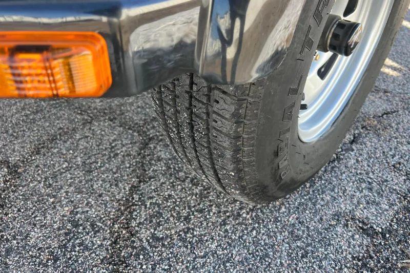 Slide: The Image of 2016 Lund 1675 Impact Sport boat side view with logo and trailer. - 25