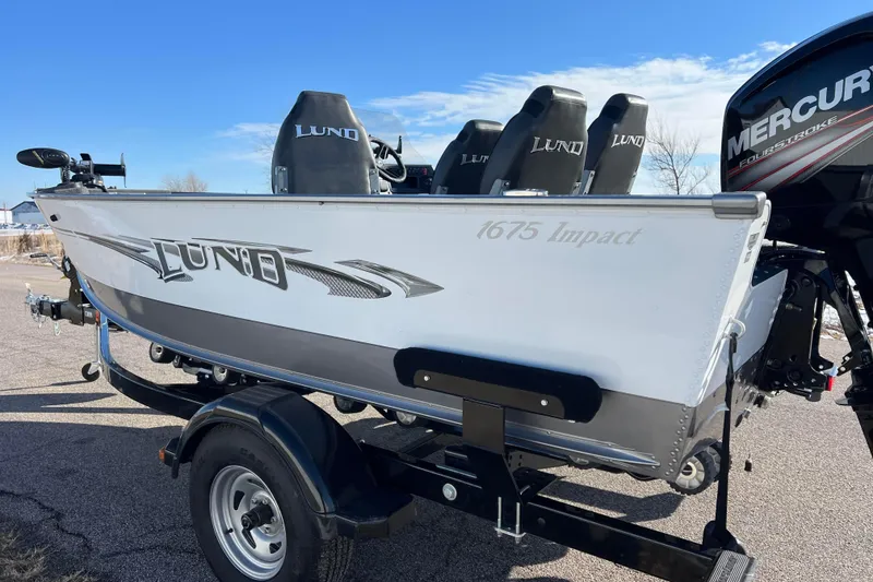 Slide: The Image of 2016 Lund 1675 Impact Sport boat with Mercury 90 engine, parked outdoors. - 4