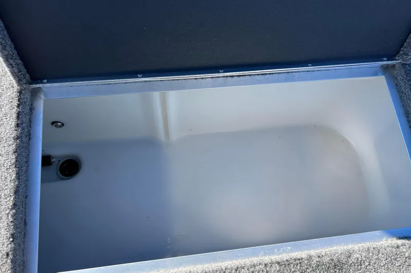 Slide: The Image of Storage compartment in a 2016 Lund 1675 Impact Sport boat, featuring a metal rod. - 43