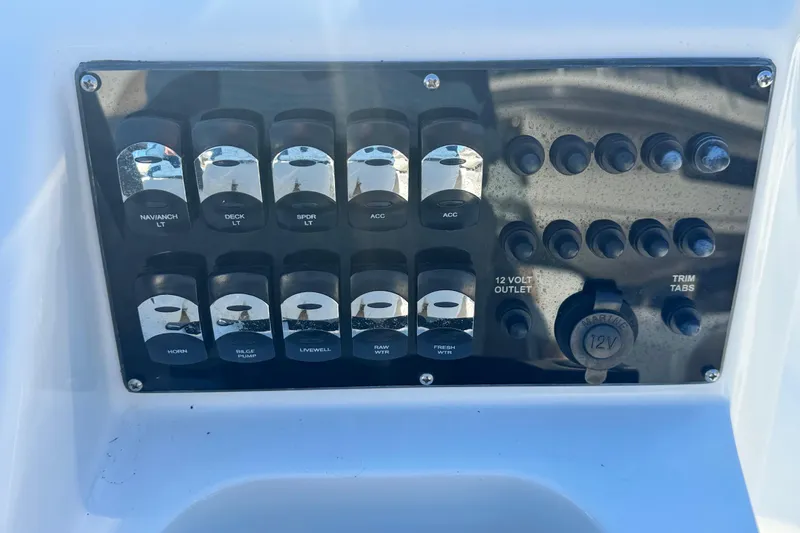 Slide: The Image of Control panel of a 2019 Edgewater 188CC boat with various switches and 12V outlet. - 5