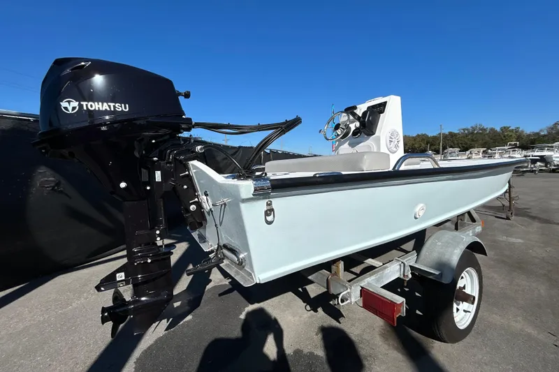 Slide: The Image of Custom FS 14 boat, 2025 model, with Tohatsu outboard motor on a trailer. - 2