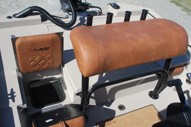 Slide: The Image of Interior of 2026 Avid 207 Recon boat with brown leather seating and storage compartments. - 16