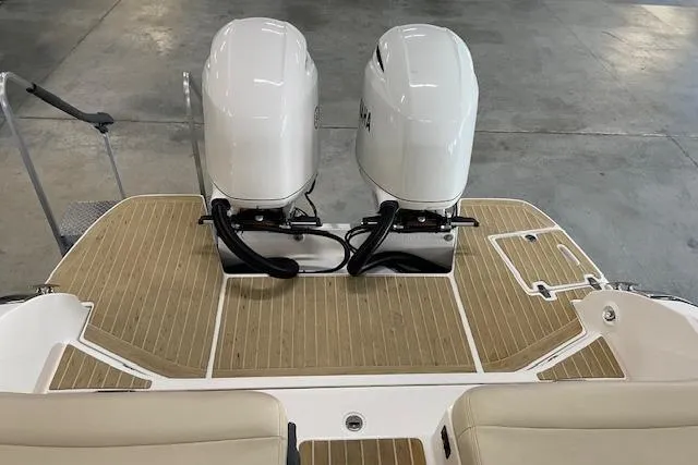 Slide: The Image of 2019 Regal 29 OBX boat with dual outboard engines and teak deck. - 18