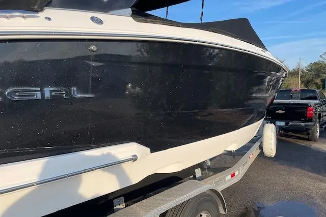 Slide: The Image of 2019 Regal 29 OBX boat on trailer, black hull, parked outdoors. - 4