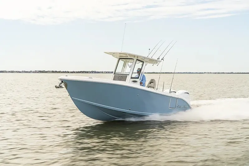 Slide: The Image of A modern blue motorboat speeds across calm water. It features a central steering console. - 31