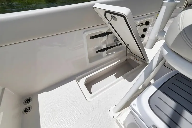 Slide: The Image of Sailfish 252 CC 2026: Open storage compartment on the boat with cushioned seat and control console. - 15