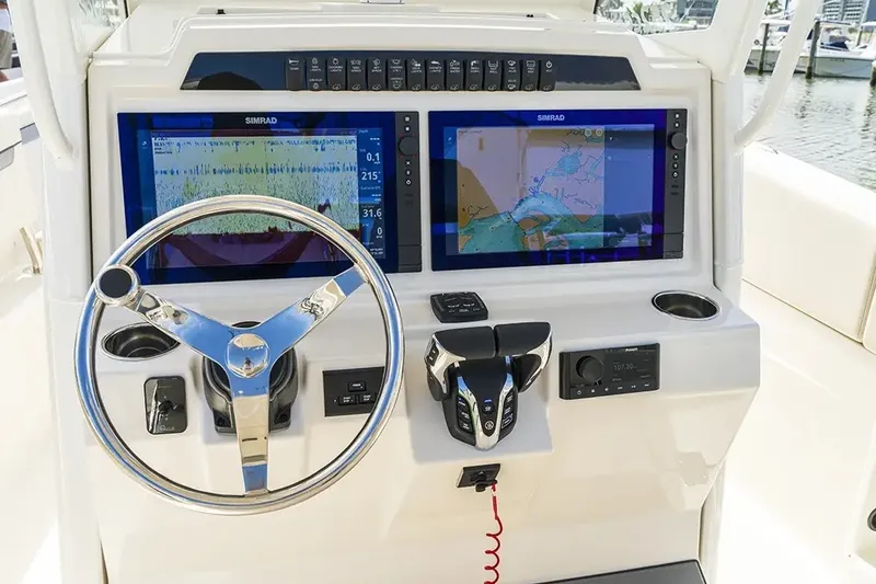 Slide: The Image of The image shows the helm of a Sailfish 252 CC boat with two large screens and a steering wheel. - 29