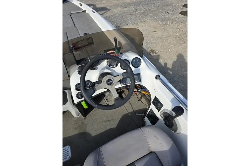 Slide: The Image of 2001 Bass Cat Cougar boat cockpit with steering wheel and dashboard controls. - 15