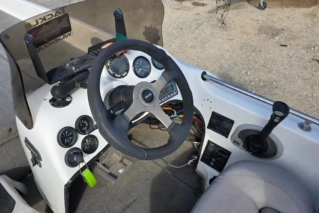 Slide: The Image of 2001 Bass Cat Cougar boat dashboard with steering wheel and control panel. - 16