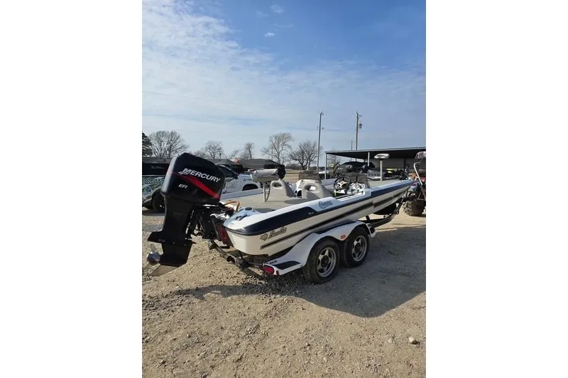 Slide: The Image of 2001 Bass Cat Cougar boat with Mercury engine on a trailer, parked outdoors. - 3