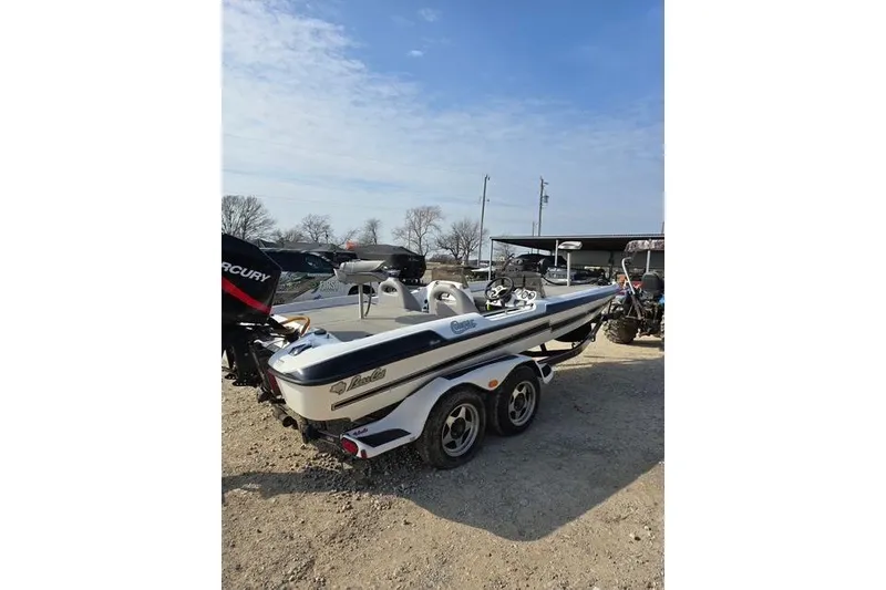 Slide: The Image of 2001 Bass Cat Cougar boat on trailer, parked outdoors under clear sky. - 5