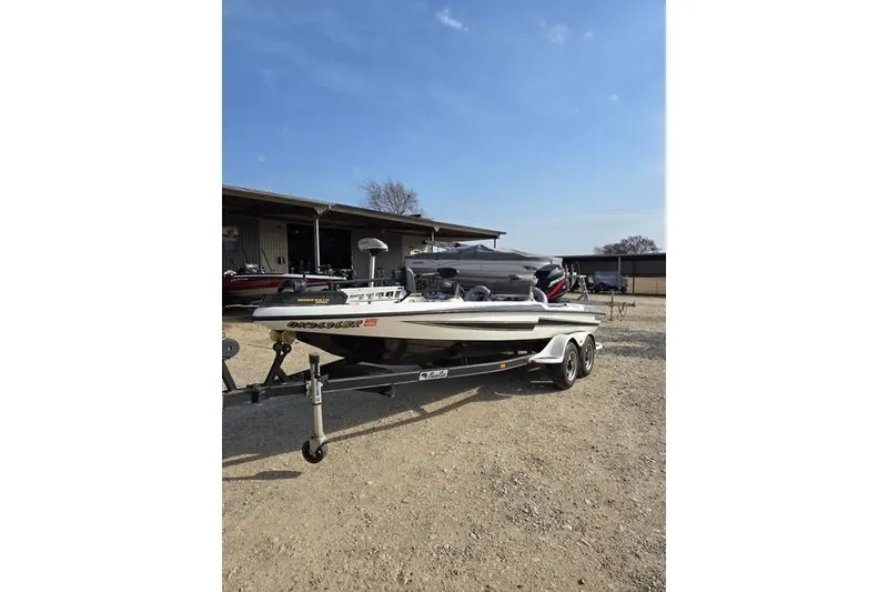Slide: The Image of 2001 Bass Cat Cougar boat on trailer under clear blue sky. - 6