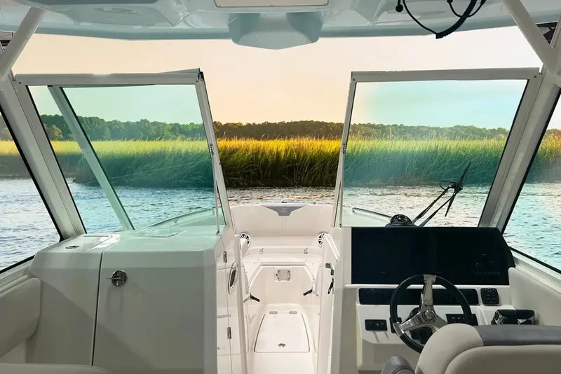 Slide: The Image of The Sailfish 276 DC cockpit offers a clear view of the water and coastal landscape. - 6