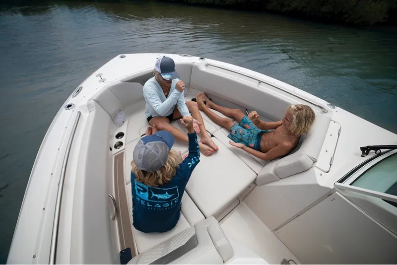 Slide: The Image of Three people relax in the bow of a Sailfish 276 DC boat on the water. - 9