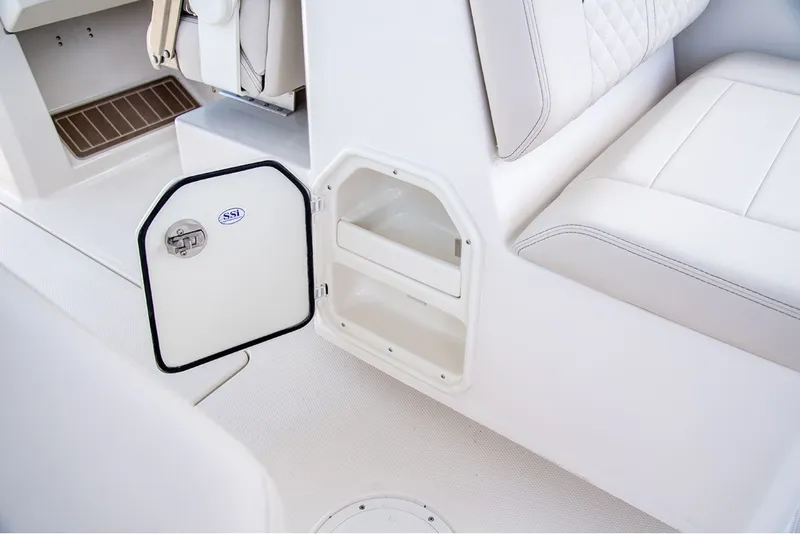 Slide: The Image of An open storage compartment on a white boat with cushioned seating. - 12