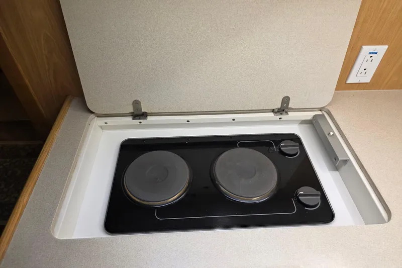 Slide: The Image of 1997 Tiara Yachts 4000 Express stove with two burners and cover in yacht kitchen. - 17