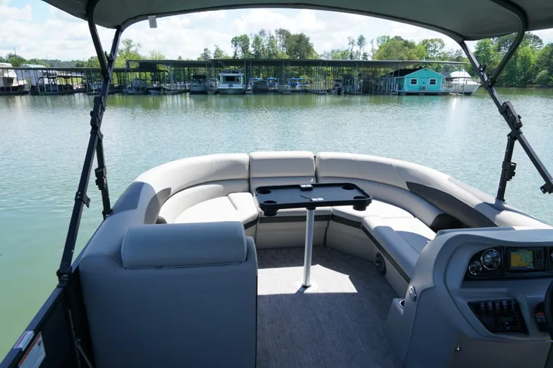Slide: The Image of 2026 Berkshire 24 RFX LE pontoon boat interior with seating and table on a serene lake. - 14