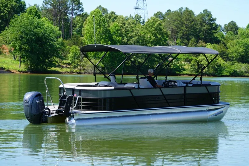 Slide: The Image of 2026 Berkshire 24 RFX LE pontoon boat cruising on a serene lake with lush greenery. - 3