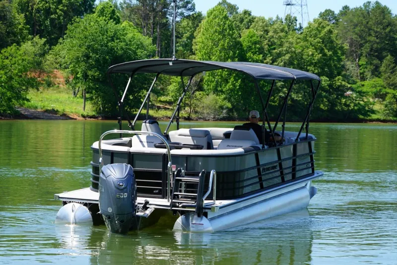 Slide: The Image of 2026 Berkshire 24 RFX LE pontoon boat cruising on a serene lake with lush greenery. - 4