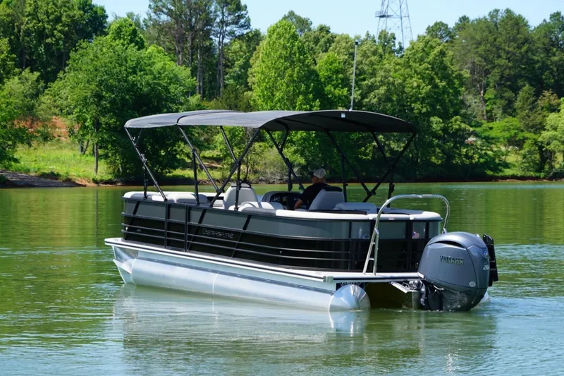 Slide: The Image of 2026 Berkshire 24 RFX LE pontoon boat on a serene lake with lush greenery. - 5