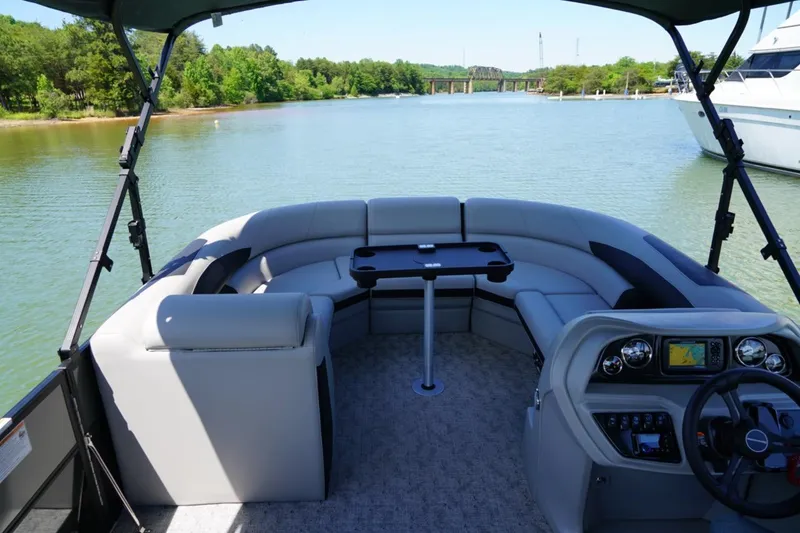 Slide: The Image of 2026 Berkshire 24 RFX LE pontoon boat interior with plush seating and scenic lake view. - 6