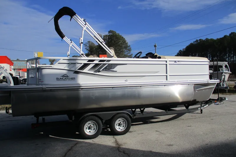 Slide: The Image of 2026 SunCatcher Select 22SL pontoon boat on trailer, parked outdoors. - 6