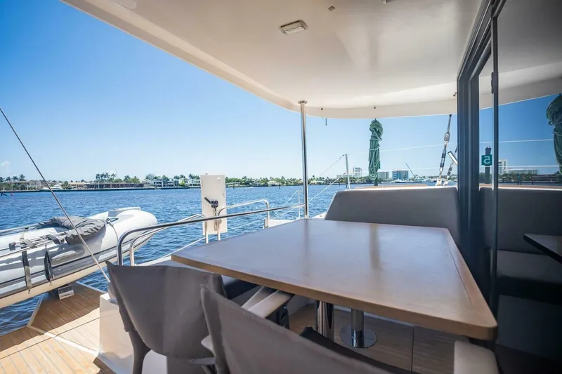 Slide: The Image of Outdoor seating area on a 2020 NEEL 51 trimaran, overlooking calm waters and distant shoreline. - 16
