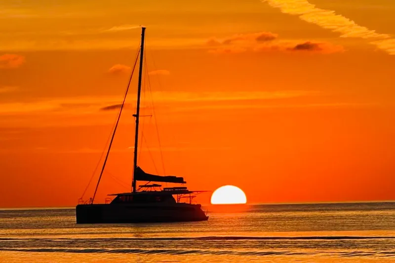 Slide: The Image of NEEL 51 trimaran sailing at sunset, 2020 model, on calm waters. - 2