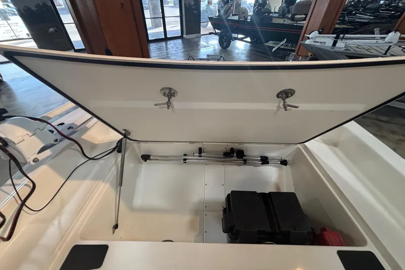 Slide: The Image of 2024 Mako Pro Skiff 15 CC storage compartment with open lid. - 9
