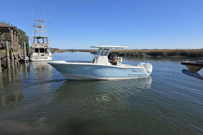 Slide: The Image of 2026 Pioneer 250 Pelagic boat navigating a calm waterway under clear blue skies. - 12