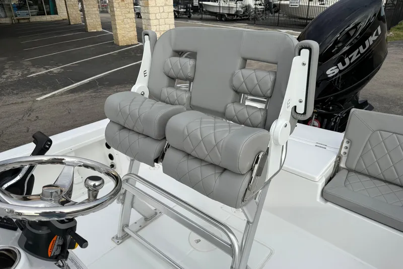 Slide: The Image of 2026 Blazer PureBay 2200 boat with gray cushioned seating and Suzuki engine. - 13