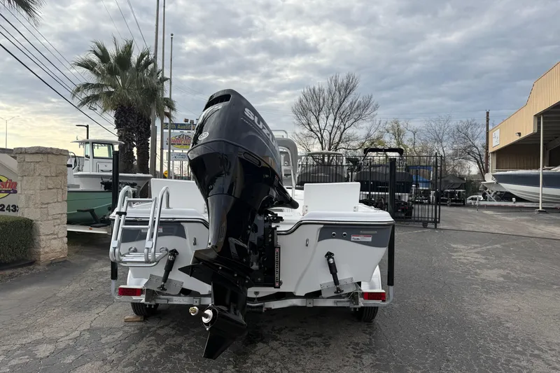 Slide: The Image of 2026 Blazer PureBay 2200 boat with Suzuki outboard motor in a marina setting. - 3