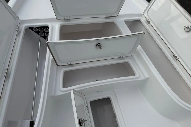 Slide: The Image of 2026 Blazer PureBay 2200 boat storage compartments with open hatches and rod holders. - 33
