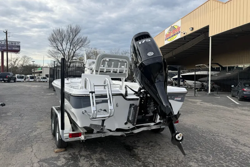 Slide: The Image of 2026 Blazer PureBay 2200 boat with 175 HP engine on trailer, parked outside dealership. - 4