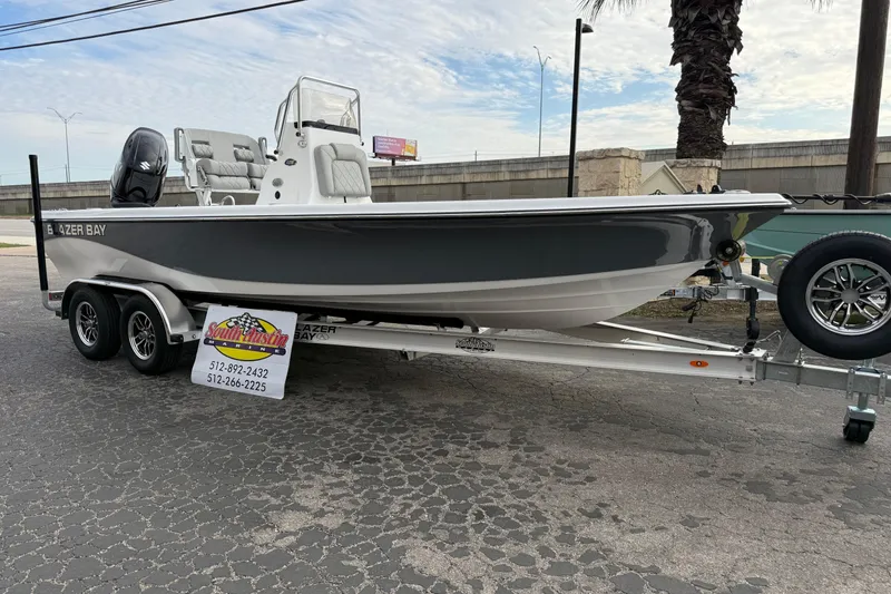 Slide: The Image of 2026 Blazer PureBay 2200 boat on trailer, displayed outdoors. - 49