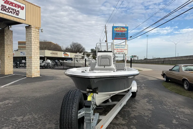 Slide: The Image of 2026 Blazer PureBay 2200 boat on trailer at dealership, under cloudy sky. - 8