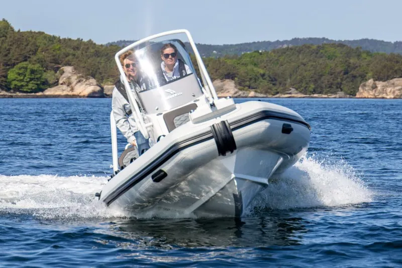 Slide: The Image of Manufacturer Provided Image: 2025 Highfield Sport 560 boat cruising on a scenic lake. - 2
