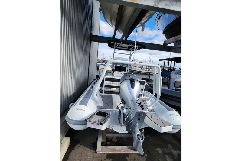 Slide: The Image of 2026 Highfield Sport 560 boat with outboard motor, docked at marina. - 7
