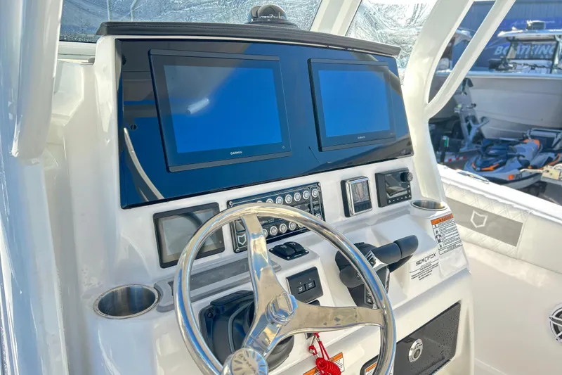 Slide: The Image of 2026 Sea Fox 288 Commander helm with dual Garmin displays and stainless steel steering wheel. - 2