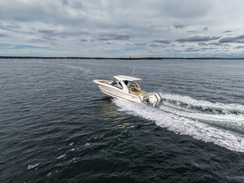 Slide: The Image of A 2027 Scout 288 Dorado speeds across the water under a cloudy sky. - 11